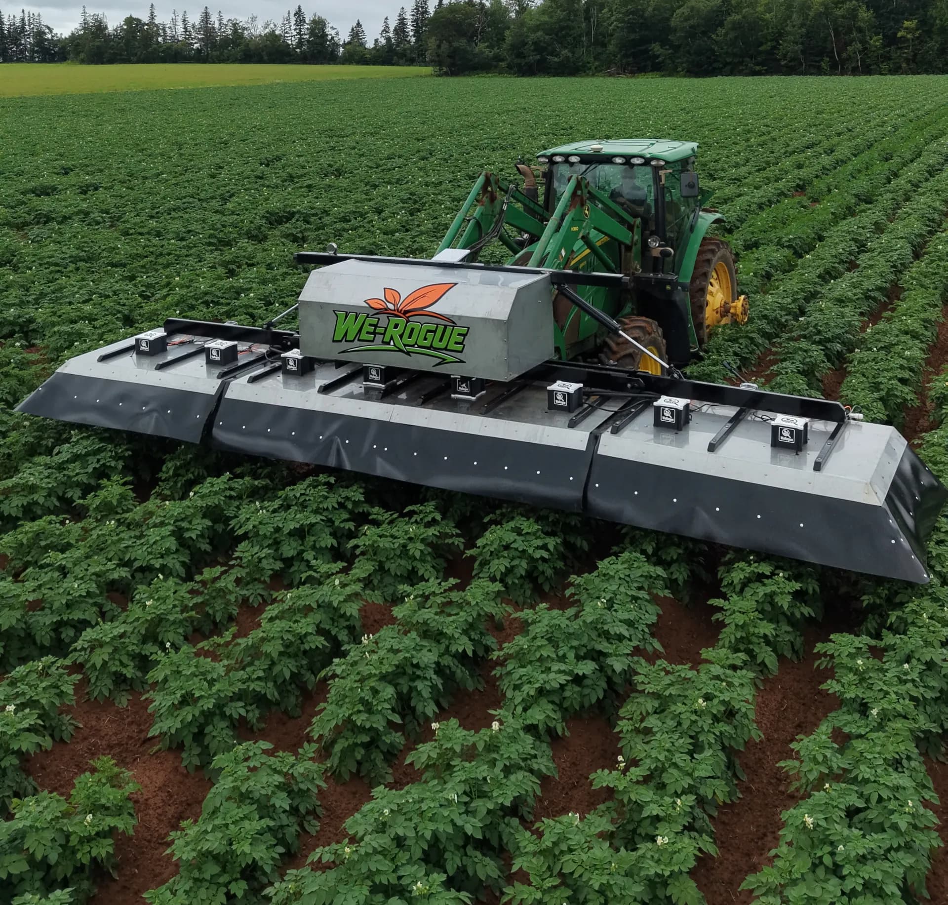 Tractor carrying the We-Rogue camera boom over potato rows