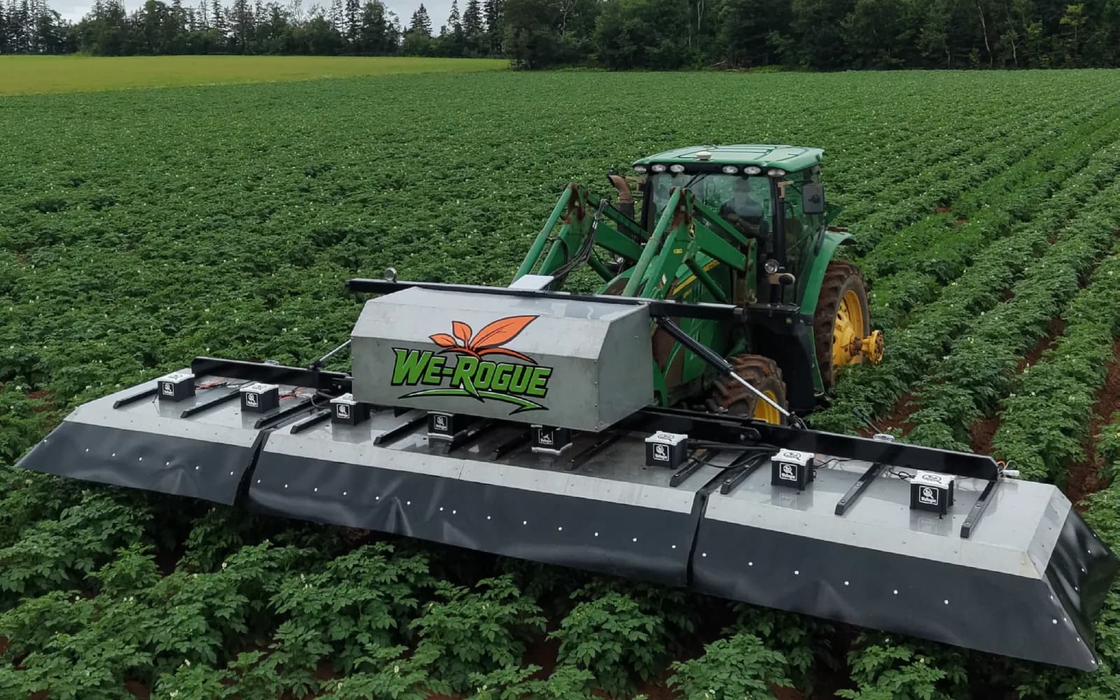 Tractor carrying the We-Rogue camera boom over potato rows